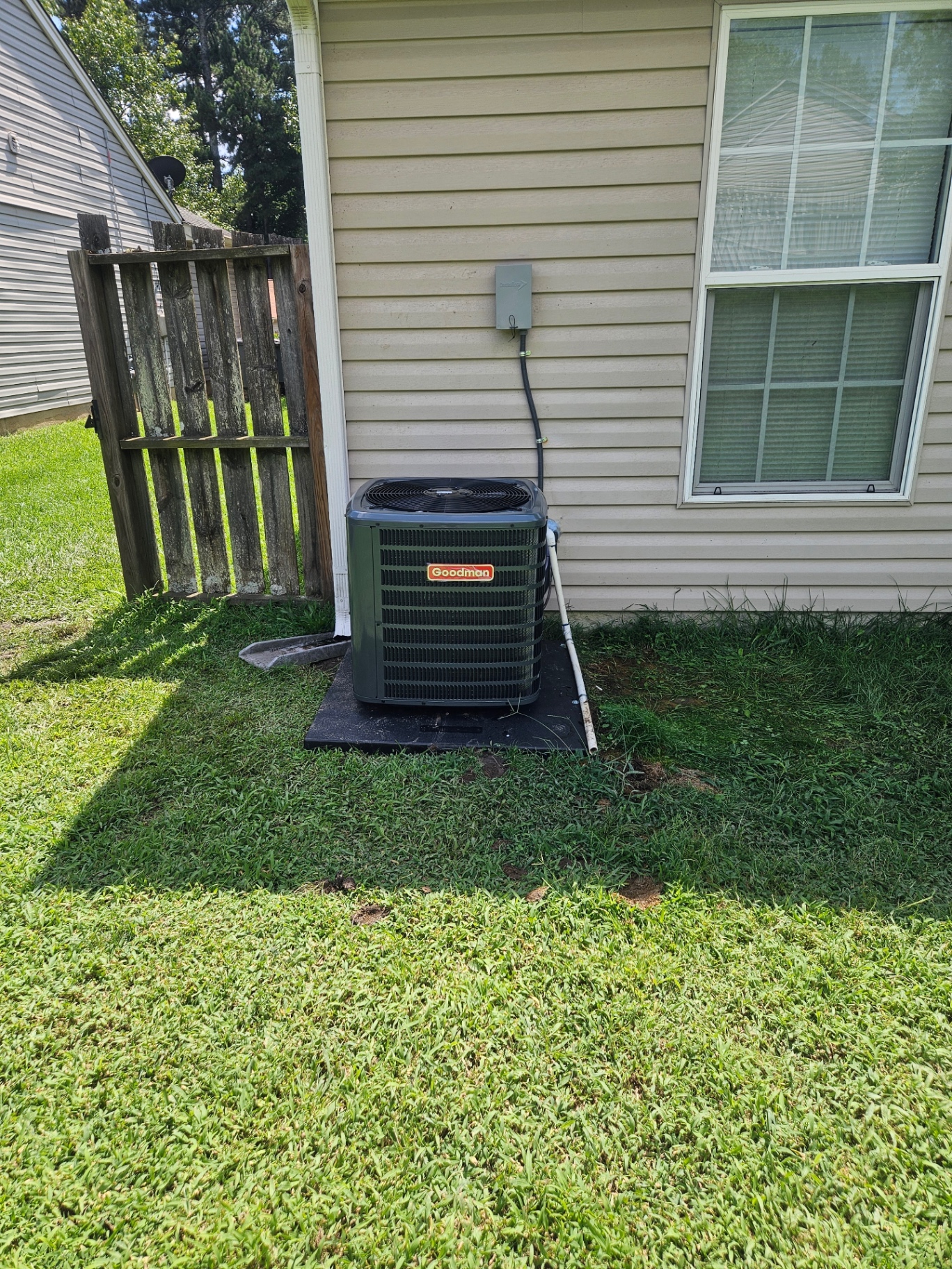 Goodman outdoor HVAC unit beside a home with siding